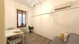 a living room with a table and a chandelier at A42 - Ancona, bilocale in pieno centro in Ancona