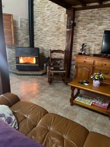 a living room with a couch and a fireplace at Casa del Espliego in Barriopedro