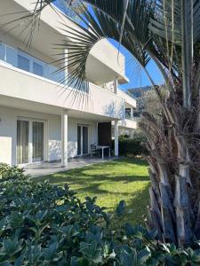 a view of a house with a palm tree at GARDA LIVING APARTMENTS Riva del Garda in Riva del Garda