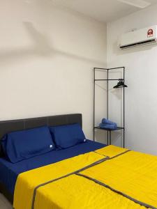a bedroom with a bed with blue and yellow sheets at Escadia Homestay in Bandar Penawar in Bandar Penawar