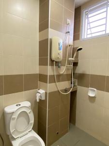 a bathroom with a toilet and a shower at Escadia Homestay in Bandar Penawar in Bandar Penawar