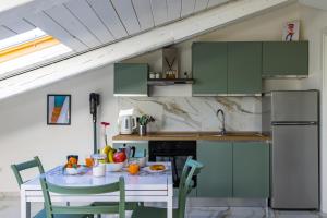 ナポリにあるA Quiet Spaceの緑のキャビネットとテーブルと椅子のあるキッチン