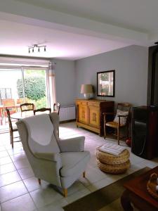 una sala de estar con un sofá y una silla en Gîte Saint Benoît sur Loire Val de Sully, en Saint-Benoît-sur-Loire