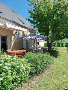 Un patio con una mesa y una sombrilla en una casa. en Gîte Saint Benoît sur Loire Val de Sully, en Saint-Benoît-sur-Loire 30 fotos más