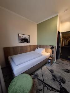 a bedroom with a large white bed and a chair at LIHO - einfach Lübeck in Lübeck