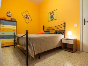 a bedroom with a bed and a yellow wall at Casa Zirocco in Sperlonga