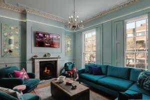 a living room with a blue couch and a fireplace at Central London House Zone 1 in London