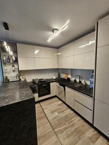 a kitchen with white cabinets and black counter tops at Azur Onyx Premium in St. St. Constantine and Helena
