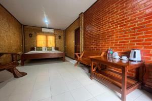 Pokój z ceglaną ścianą i drewnianym stołem w obiekcie PAI Hillside Resort w mieście Mae Hong Son