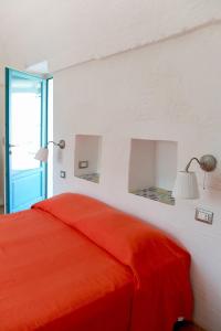 a bedroom with a red bed and a window at Masseria Palombara Grande in Ostuni