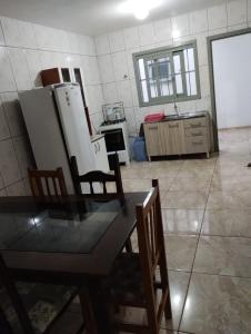 a kitchen with a table and chairs and a refrigerator at Apartamento superior 04 quartos in Torres