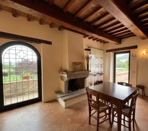 a dining room with a table and a fireplace at Agricola Caicucci in Montone