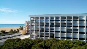 ビビオーネにあるCondominio auriga del soleのビーチを背景にしたアパートメントビル