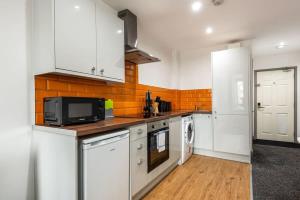 a kitchen with white cabinets and a microwave at Budget 1 Bed Flat in Halifax Centre in Halifax