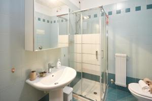a bathroom with a sink and a glass shower at Cozy Place Sacile Centre Parking & AC in Sacile +16 photos