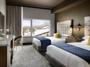 een hotelkamer met twee bedden en een bureau bij The Josie Hotel, Autograph Collection in Rossland