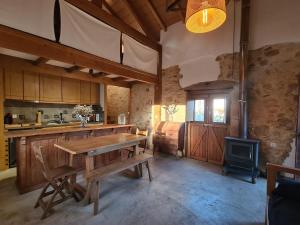 a kitchen with a wooden table and a stove at Quinta dos Milagres Casa dos Bigodes in Friumes