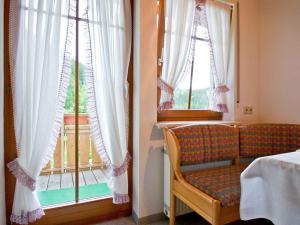 a room with a bed and a window with a chair at Gästehaus Herrmann in Wolf