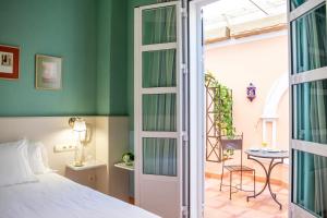 a bedroom with a bed and a door leading to a patio at Hotel Veracruz in Utrera