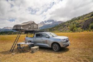 a truck parked in a field with a tent on top at Camper camioneta equipada cajon del maipo in San José de Maipo +29 photos