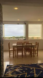 a dining room with a table and chairs and a large window at Tangier Beach in Tangier +10 photos