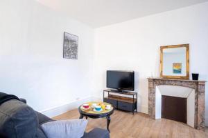 a living room with a couch and a fireplace at Le Boujou - Place de parking - 200m plage in Étretat