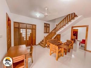 a living room with a table and chairs and a staircase at The Village Wellawaya in Wellawaya