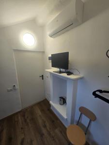 a room with a desk with a computer monitor on it at Grazioso Room in Milan
