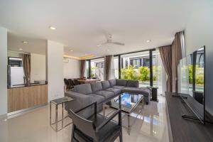 a living room with a couch and a table at Private pool villa bangtao - laguna park in Ban Phru Champa