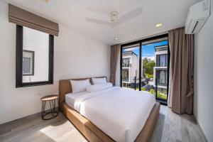 a bedroom with a white bed and a large window at Private pool villa bangtao - laguna park in Ban Phru Champa +55 photos