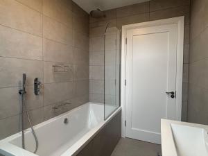 a bathroom with a bath tub and a shower at Cottage 482 - Clifden in Clifden +32 photos