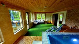 a room with a swimming pool and a living room at RelaxRitual in Līči