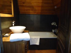 a bathroom with a bath tub and a sink at Gîte de l'Abreuvoir in Vic-sur-Cère +13 photos