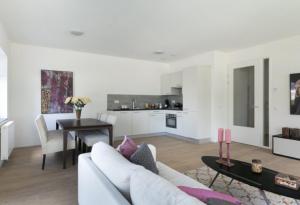 a white living room with a white couch and a table at 2 chambres WC séparés in Saint-Germain-du-Crioult