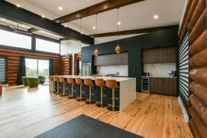 una cucina con bancone e un bar con sedie di Sommet White Golf Hot tub Ski 10min a Saint-Faustin