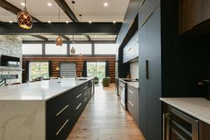 una cucina con armadi neri e ripiani bianchi di Sommet White Golf Hot tub Ski 10min a Saint-Faustin