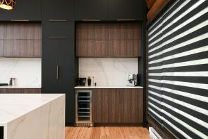 una cucina con armadietti bianchi e neri e un bancone di Sommet White Golf Hot tub Ski 10min a Saint-Faustin Altre 44 foto