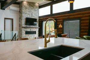 una cucina con lavandino e camino di Sommet White Golf Hot tub Ski 10min a Saint-Faustin