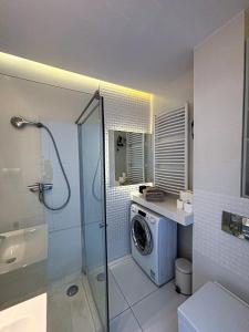 un bagno con doccia e lavatrice di Apartament Voir a Rzeszów
