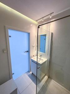 un bagno con doccia in vetro e lavandino di Apartament Voir a Rzeszów