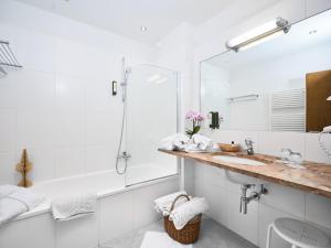 biała łazienka z umywalką i prysznicem w obiekcie Hotel Sonnalm - SPA,Idyll,Dining w mieście Bad Kleinkirchheim