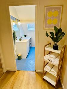 a room with a bathroom with a sink and a shelf with towels at Maison le B - Disneyland Paris - Parking - Wifi in Bussy-Saint-Georges