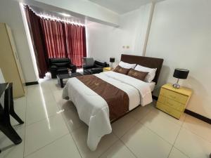 a bedroom with a large bed and a living room at Hotel Orlak in Huancayo