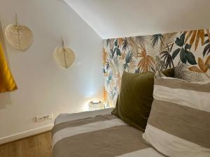 a bedroom with a bed with a green pillow at Maison le B - Disneyland Paris - Parking - Wifi in Bussy-Saint-Georges