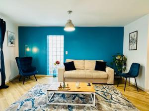 a living room with a couch and a blue wall at Maison le B - Disneyland Paris - Parking - Wifi in Bussy-Saint-Georges