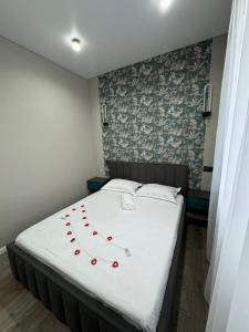 a bed with red roses on it in a room at Gold Apple apartments in Oral +14 photos