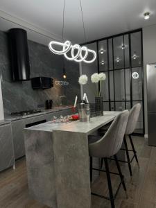 a kitchen with a large marble island with chairs at Gold Apple apartments in Oral