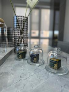 three glass jars sitting on a marble counter top at Gold Apple apartments in Oral