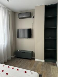 a bedroom with a bed and a tv on the wall at Gold Apple apartments in Oral