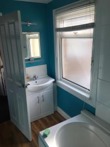 a bathroom with a white sink and a window at Tranquil Darlington Home 3BR Pet Friendly in Darlington
